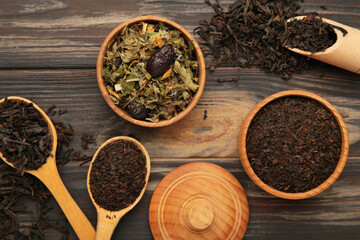 Assortment of dry tea on brown wooden background