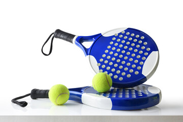 Set of paddle tennis rackets and balls on table isolated - obrazy, fototapety, plakaty