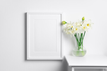 Blank white picture frame mockup with flowers in scandinavian style room interior