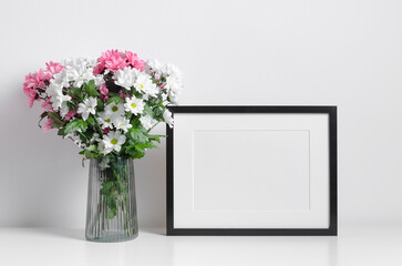 Blank landscape frame mockup with fresh flowers bouquet in white room interior