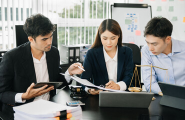 Asian business team and lawyers discussing contract papers sitting at the table. Concepts of law, advice, legal services. at office