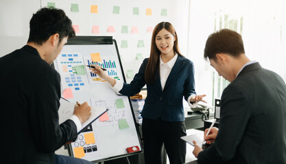 The boss stands near the board with graphs, demonstrates statistics, various personnel attending the training, introduces the new products of the company, in office.