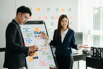 The boss stands near the board with graphs, demonstrates statistics, various personnel attending the training, introduces the new products of the company, in office.