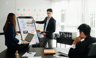 The boss stands near the board with graphs, demonstrates statistics, various personnel attending the training, introduces the new products of the company, in office.
