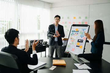 The boss stands near the board with graphs, demonstrates statistics, various personnel attending the training, introduces the new products of the company, in office.