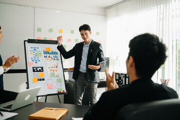 The boss stands near the board with graphs, demonstrates statistics, various personnel attending the training, introduces the new products of the company, in office.