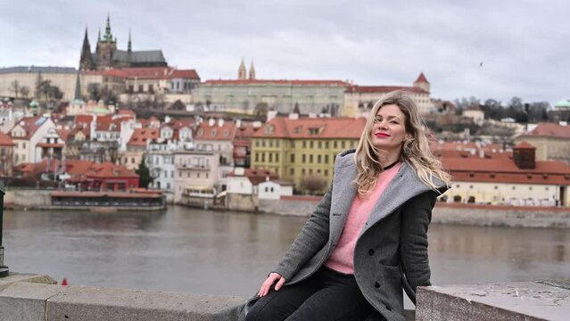a pretty woman poses for the camera, in Prague on the Charles Bridge
