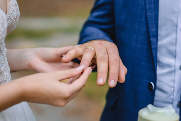 Obraz na płótnie Canvas Bride putting the wedding ring to the groom
