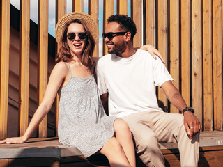 Smiling beautiful woman and her handsome boyfriend. Woman in casual summer clothes. Happy cheerful family. Female having fun. Sexy couple posing in the street at sunny day. In hat and sunglasses