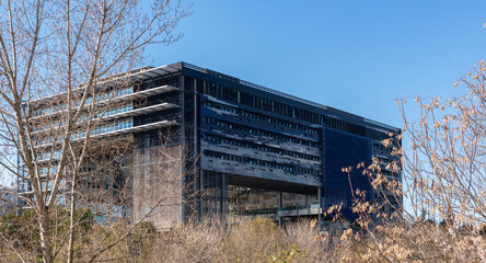 Mairie de Montpellier vue du Lez avec un jardin et de la verdure au premier plan par une journée ensoleillée ans nuage.