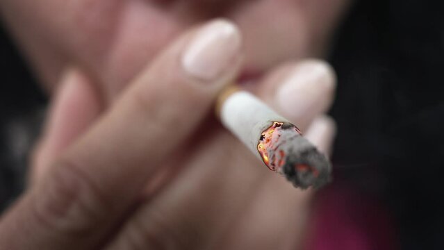Closeup woman hand smoking cigarette ,unhealthy lifestyle concept, slow motion