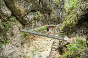 Caucasian hiker in  the Lammerklamm posing on a bridge george during summer with the river and...
