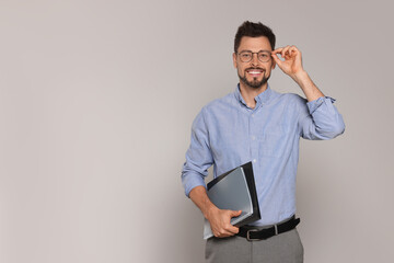 Happy teacher with glasses and stationery against beige background. Space for text
