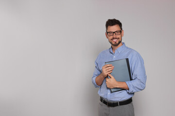 Happy teacher with glasses and stationery against beige background. Space for text