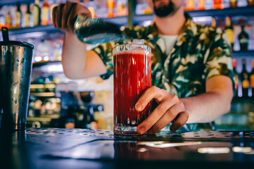 man hand bartender making cocktail in glass on the bar counter