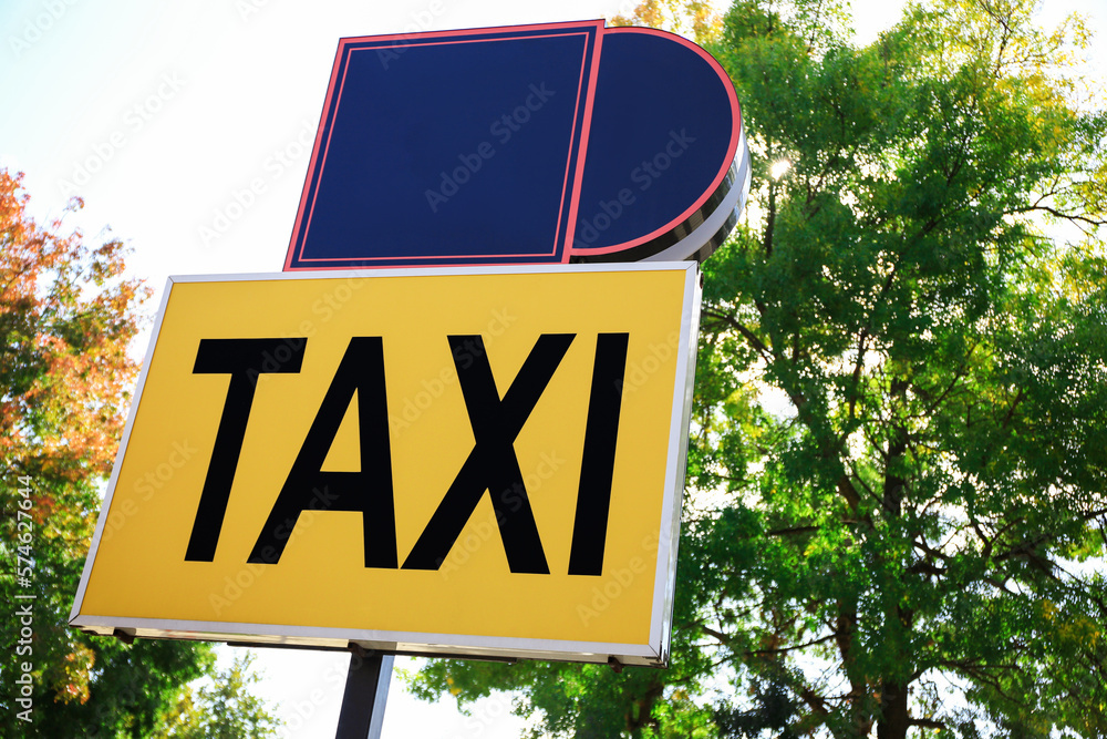 Wall mural Post with Taxi sign on city street