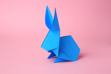 Origami art. Paper rabbit on pink background