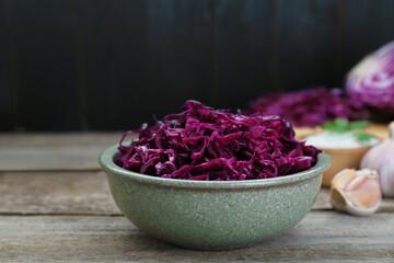 Obraz na płótnie Canvas Tasty red cabbage sauerkraut with parsley on wooden table