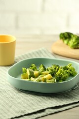 Pieces of boiled broccoli and squash on grey table, space for text. Child's food