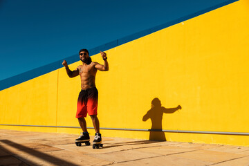  Black man on roller skates riding outside. Urban man posing with roller skates
