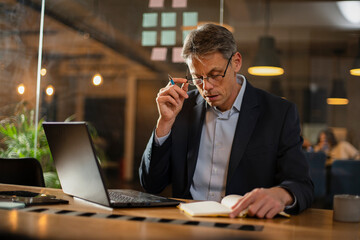 Businessman working with laptop at office. Businessman sitting at office desk working on laptop computer