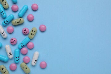 Different antidepressants with emoticons on light blue background, flat lay. Space for text