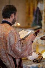 The priest reads a prayer in the church