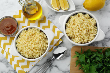Tasty couscous and ingredients on white marble table, flat lay