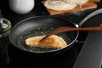 Cooking chebureki with tasty filling in frying pan