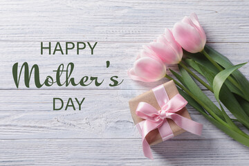 Happy Mother's Day. Beautiful tulip flowers and gift box on white wooden background, flat lay