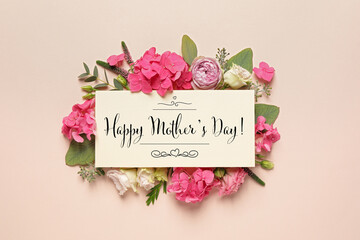 Happy Mother's Day greeting card and beautiful flowers on beige background, flat lay