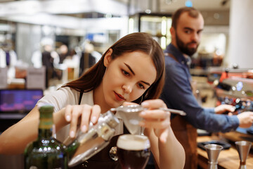 Two baristas work on creating coffee in a coffee shop