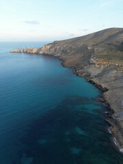 View over the shoreline of Marlloca, Spain, on a sunny afternoon in Summer with beatiful rock formations in the back