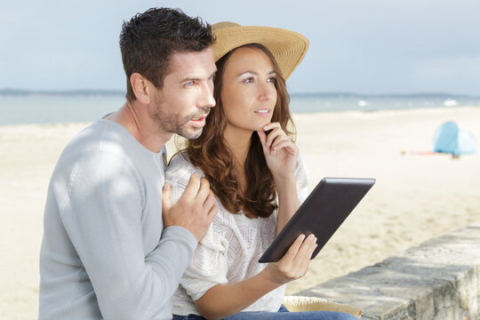 couple with tablet by seaside outdoor