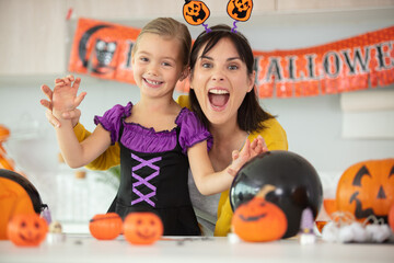 a mother and her daughter preparing for halloween