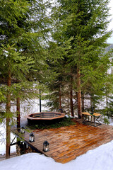 outdoor hot tub in the mountains for spa and relaxation in nature in winter, therapeutic effects of...