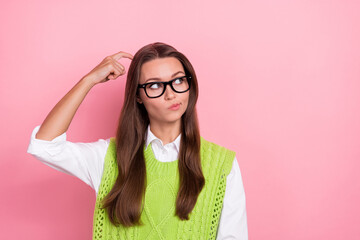 Photo of young funny genius college teacher girl pouted lips scratch head finger look empty space choose product isolated on pink color background