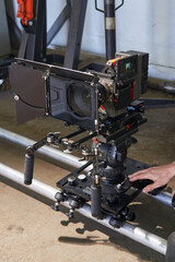 caucasian hand of a videographer rolls a professional movie camera on a camera trolley along the rails. adjusts flatness and horizon