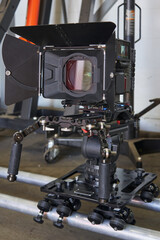 general view of a professional film camera, which stands on a camera trolley with wheels on rails