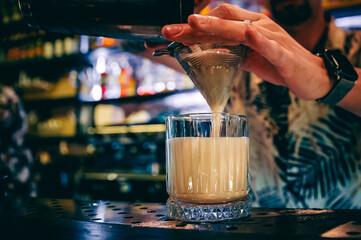 man hand bartender making cocktail in glass on the bar counter