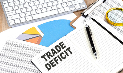 TRADE DEFICIT text on notebook with chart and keyboard - obrazy, fototapety, plakaty