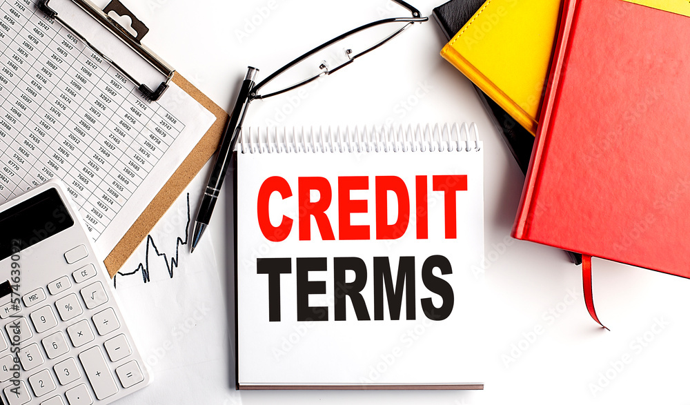 Aufkleber credit terms text on notebook with clipboard and calculator on white background