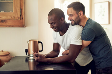 Soft homosexual men embracing and browsing smartphone
