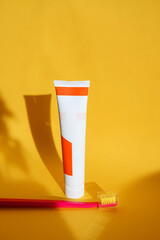 red toothbrush and toothpaste on yellow background., space for text. Oral hygiene. Dental concept. healthcare.