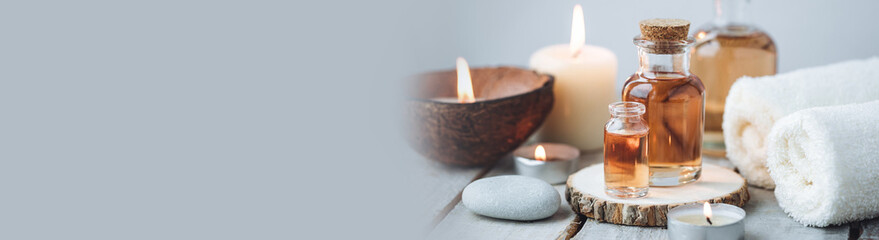 Concept of spa treatment in salon with pure organic natural oil. Atmosphere of relax, detention. Aromatherapy, candles, towel, wooden background. Skin care, body gentle treatment