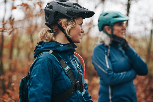 Smiling daughter and mother peparing to go mountain biking together