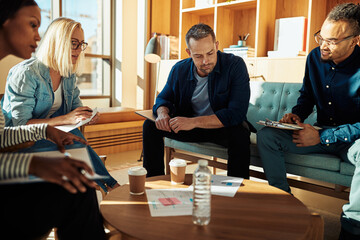 Diverse businesspeople going over paperwork during an office meeting
