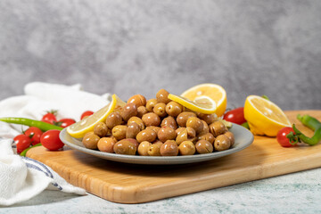 Scratched green olives. Brined scratched green olives on a wood serving board. low angle view