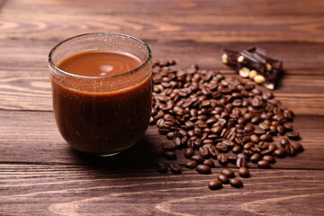 Hot coffee mug and beans on wooden table