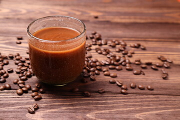 Hot coffee mug and beans on wooden table
